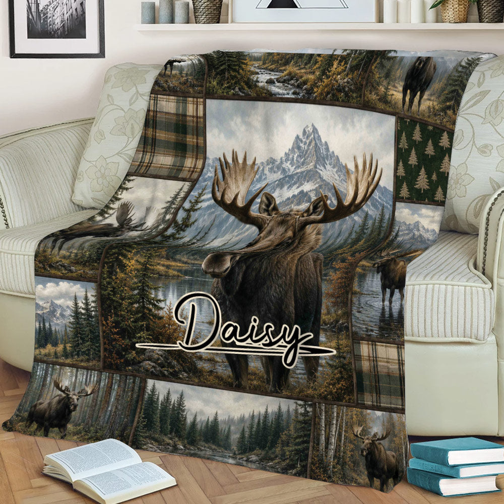 Close view of a moose throw blanket displayed on a sofa with scenic wilderness and mountain artwork