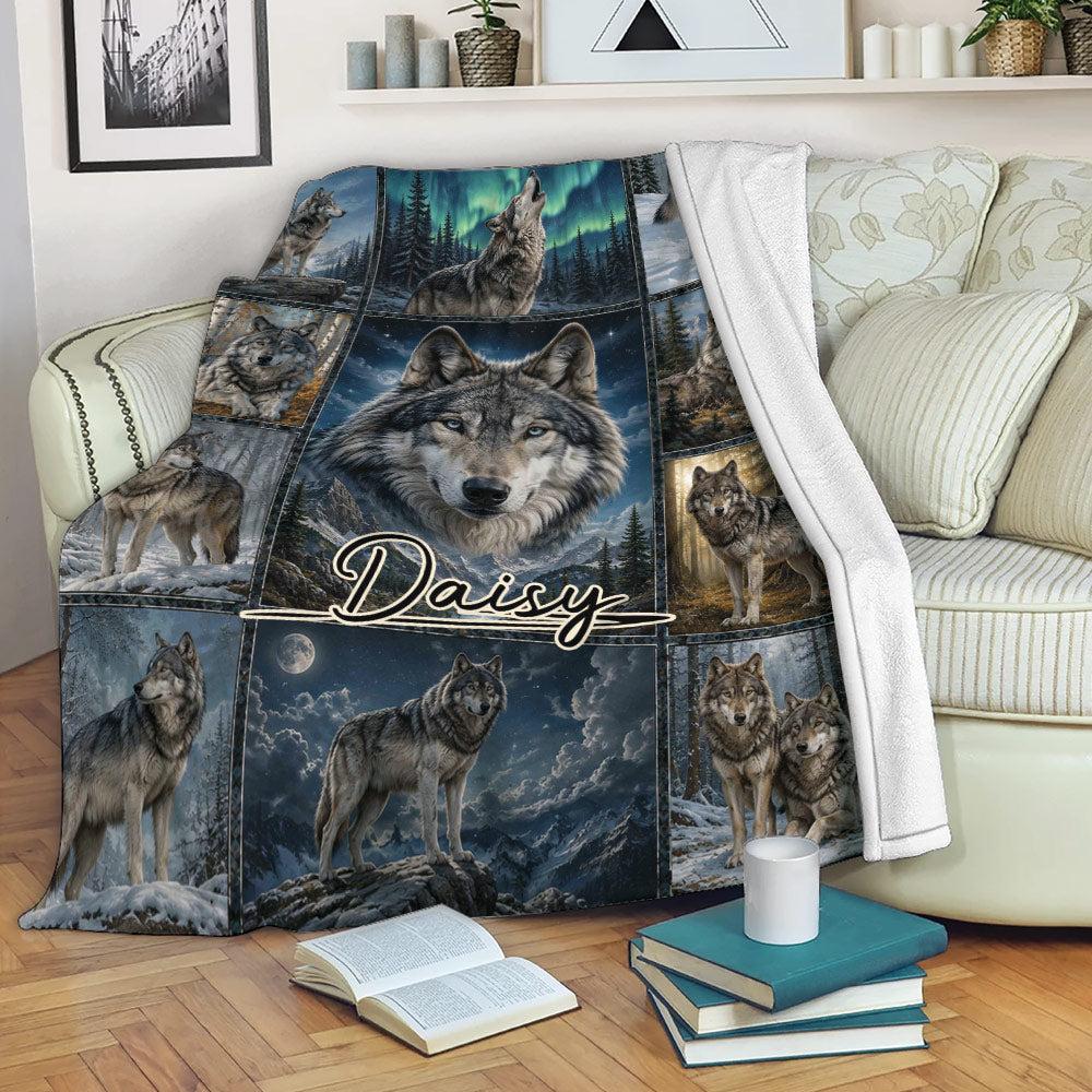 Wolf blanket draped over a sofa, showing a large wolf portrait surrounded by snowy forest and mountain scenes