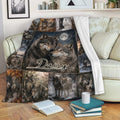 Wolf throw blanket draped over a sofa, featuring a moonlit wolf pair and woodland collage artwork