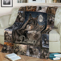 Close view of a wolf blanket on a sofa with detailed wildlife scenes and a moonlit wolf pair
