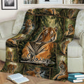 Tiger blanket spread across a couch featuring multiple tigers surrounded by dense forest artwork