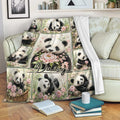 Floral panda blanket draped over a sofa, showing playful pandas, bamboo, and pink flower artwork