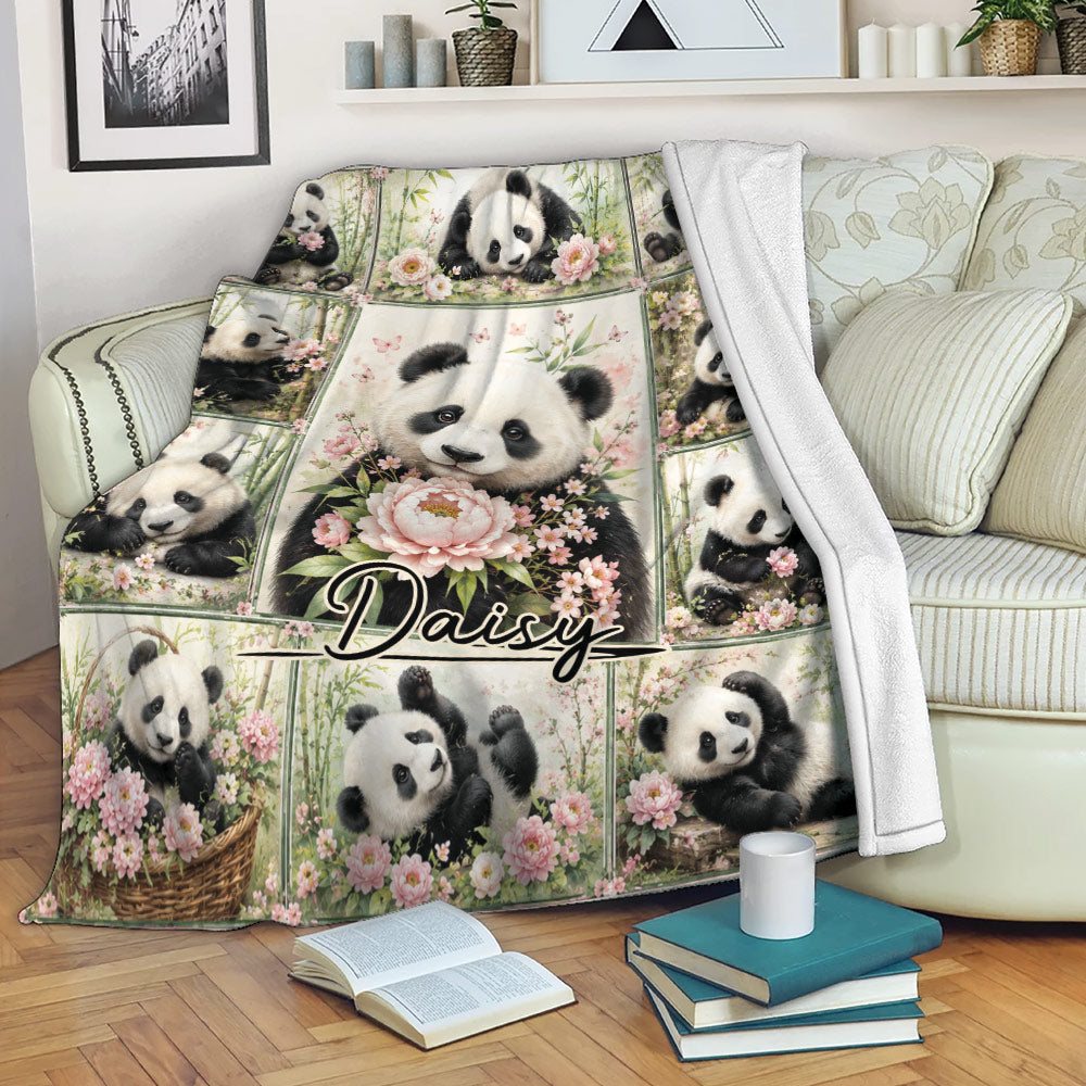 Floral panda blanket draped over a sofa, showing playful pandas, bamboo, and pink flower artwork