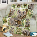 Close view of a koala throw blanket on a sofa featuring eucalyptus branches and woodland scenes