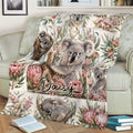 Australian koala blanket displayed on a sofa with botanical panels, sleeping koalas, and floral artwork