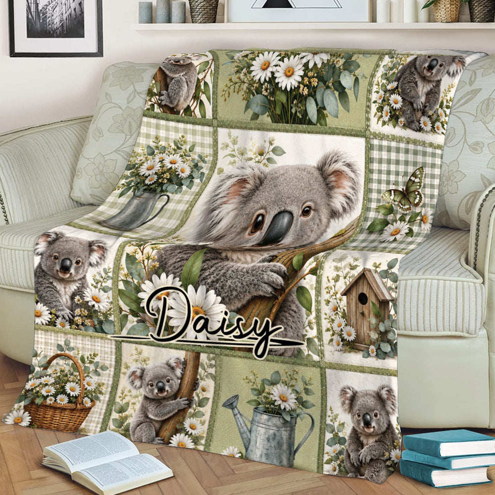 Close lifestyle view of a koala throw blanket with floral patchwork artwork draped across a sofa
