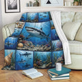 Shark blanket draped over a sofa with blue underwater artwork, coral reefs, and ocean wildlife