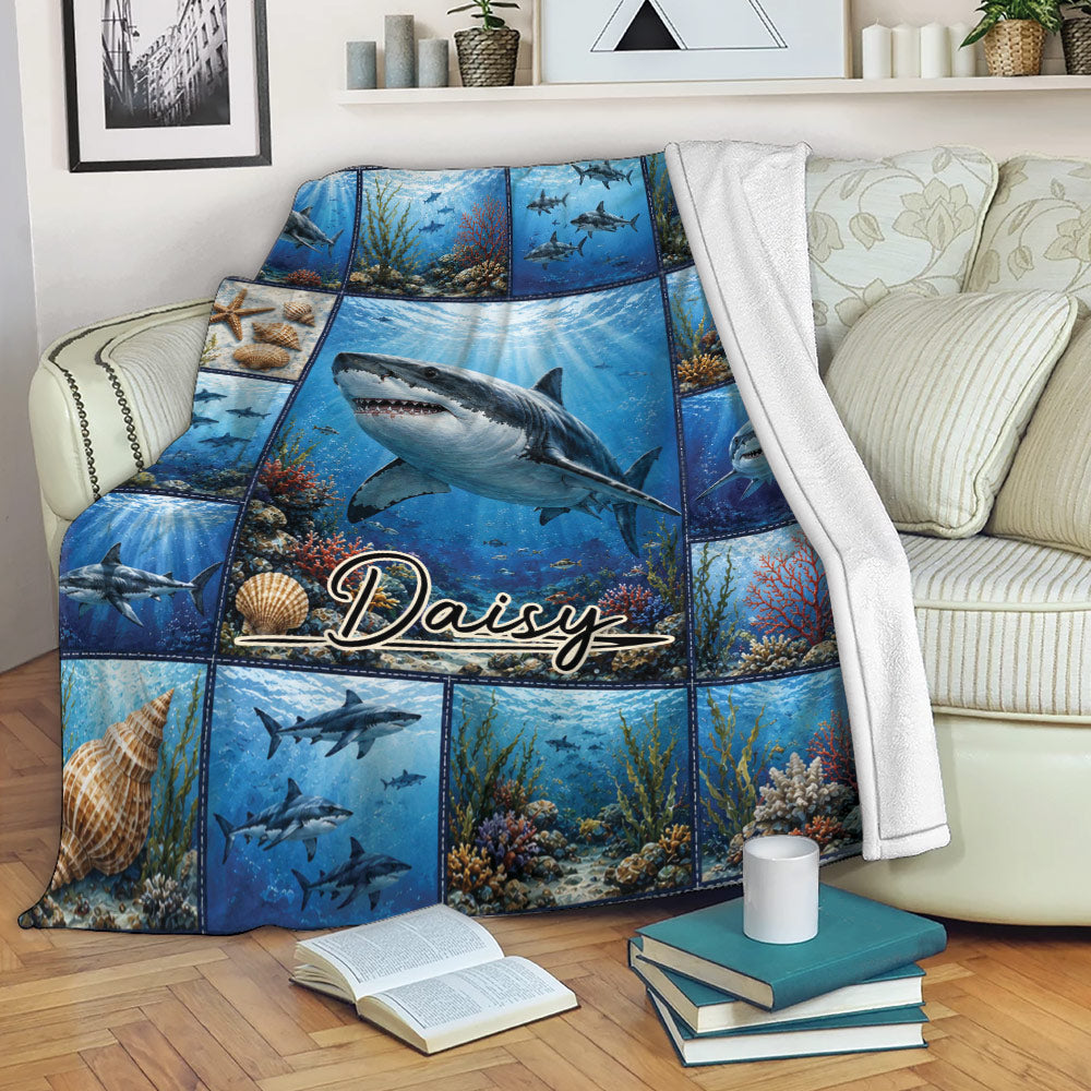 Shark blanket draped over a sofa with blue underwater artwork, coral reefs, and ocean wildlife