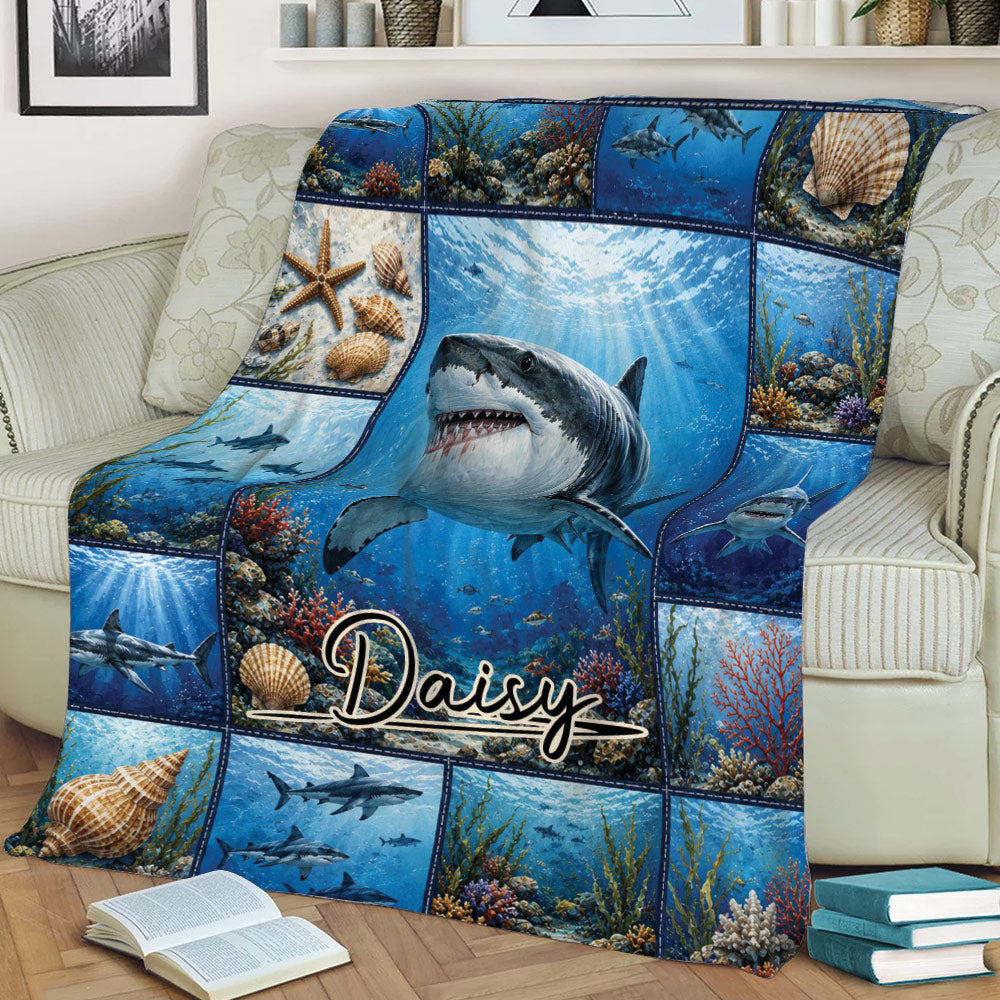 Shark throw blanket displayed across a couch with underwater scenes, seashells, and coral artwork