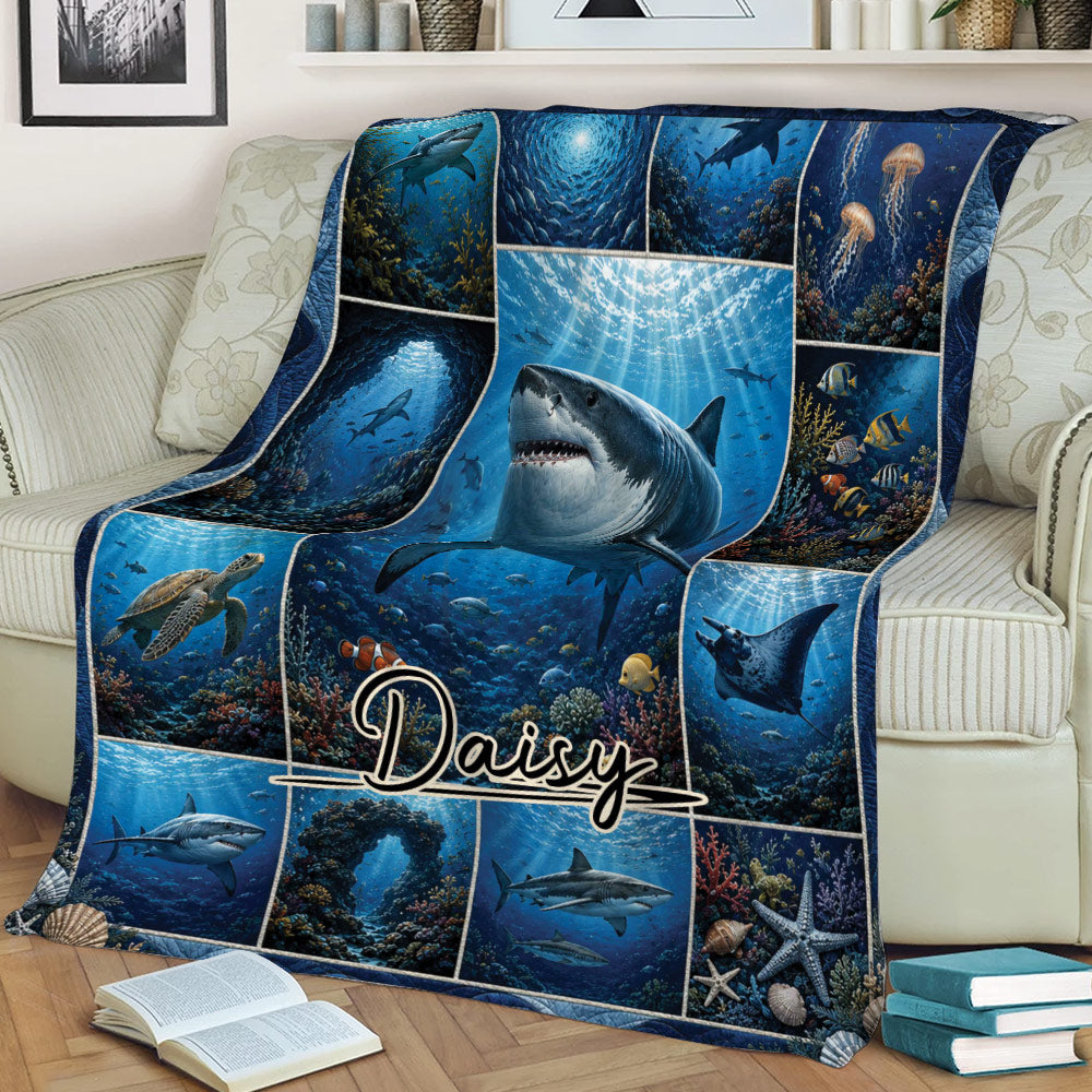 Close lifestyle view of a shark blanket on a sofa with coral reefs and deep sea artwork