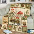 Vintage botanical mushroom blanket styled on a sofa with illustrated fungi, baskets, ferns, leaves, and berries