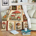 Mushroom throw blanket draped over a sofa with vintage fungi, fern, leaf, and woodland artwork