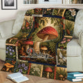 Mushroom blanket displayed on a couch with red toadstools, forest plants, flowers, and butterflies