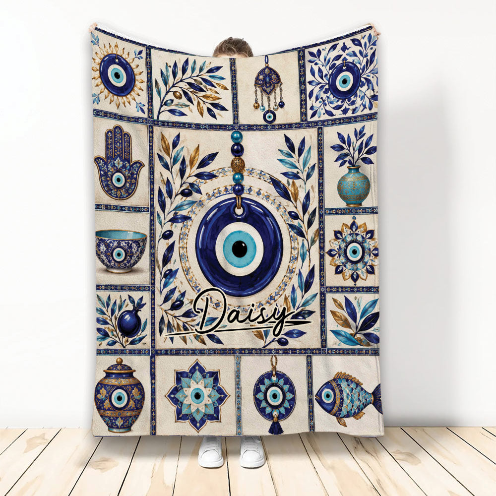 Evil Eye throw blanket with blue Nazar motifs, Hamsa symbols, botanical accents, and decorative pottery artwork