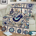 Evil Eye blanket draped over a sofa, featuring blue Nazar designs, Hamsa hands, pottery, and floral details