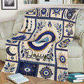 Blue Evil Eye blanket styled across a sofa with repeated nazar symbols, floral artwork, and ornate decorative borders