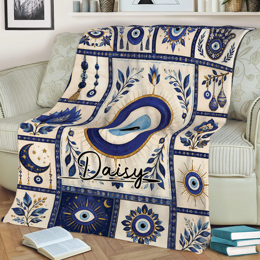 Blue Evil Eye blanket styled across a sofa with repeated nazar symbols, floral artwork, and ornate decorative borders