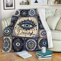 Evil eye throw blanket with blue mandala pattern draped over a living room sofa