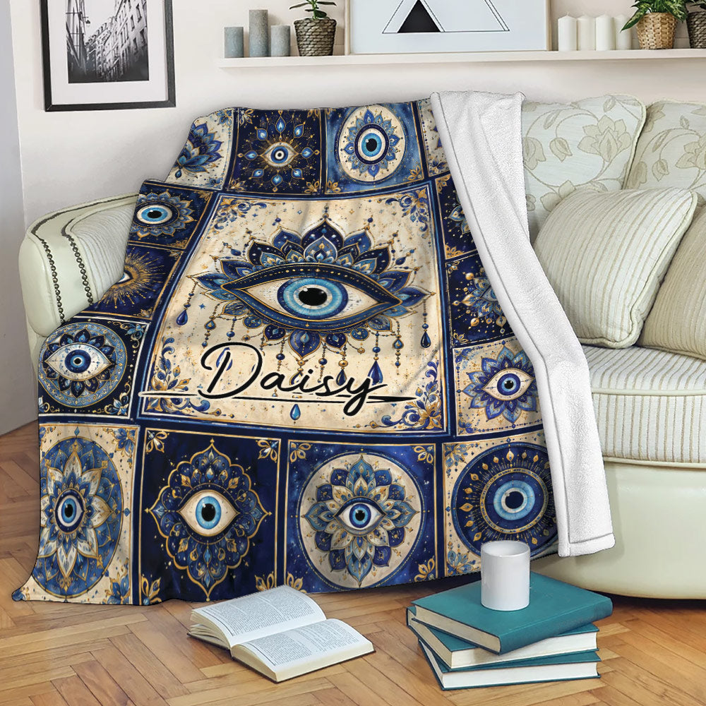 Evil eye throw blanket with blue mandala pattern draped over a living room sofa