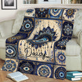 Ornate blue evil eye blanket featuring a large central eye design on a sofa