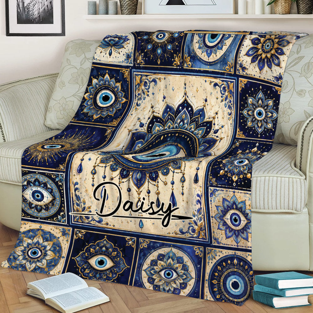 Ornate blue evil eye blanket featuring a large central eye design on a sofa