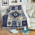 Evil eye throw blanket styled over a sofa with blue ornamental artwork and floral details