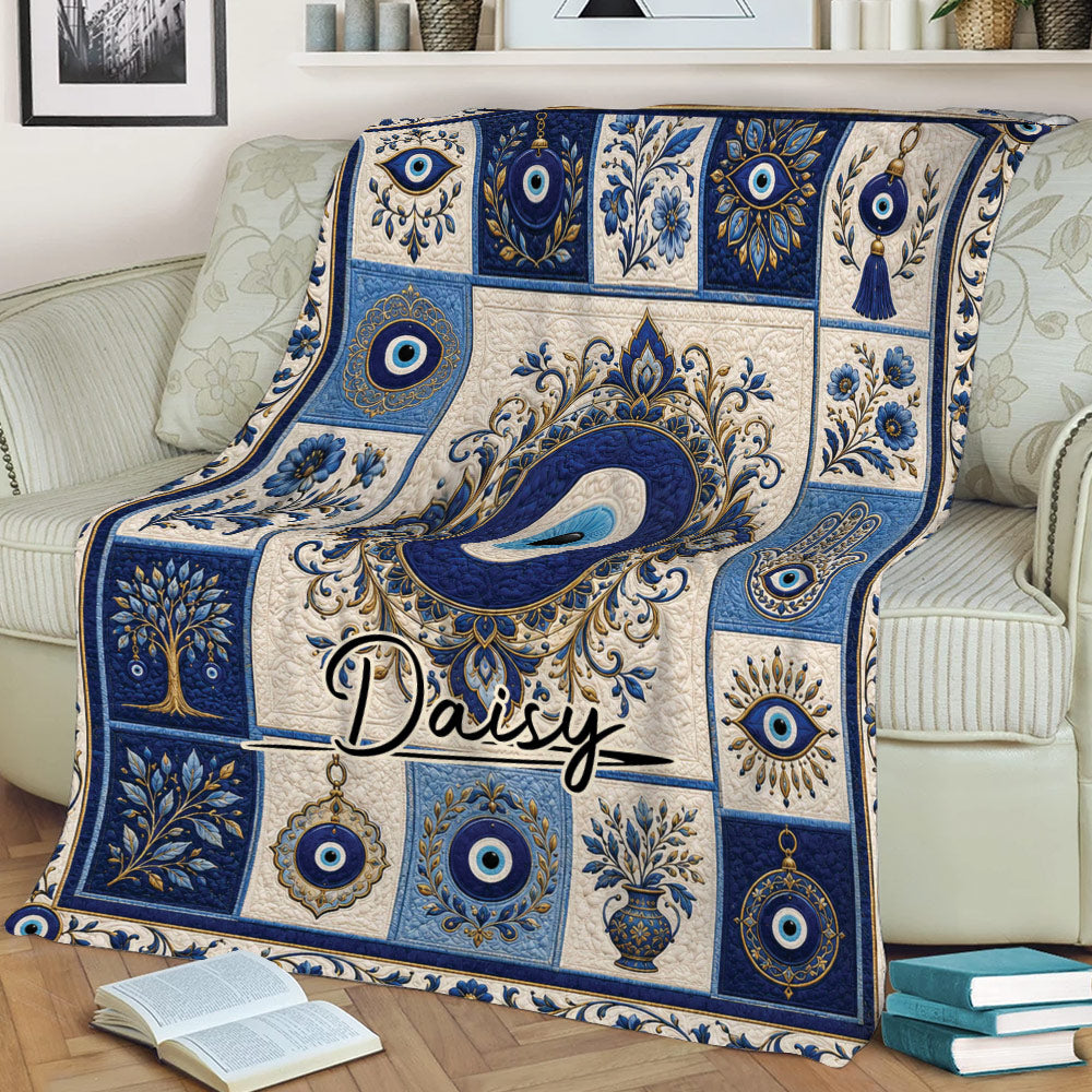 Decorative evil eye blanket draped across a sofa, featuring blue eyes, hamsa art, and botanical motifs