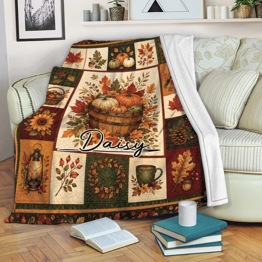 Autumn harvest throw blanket draped over a sofa with pumpkins, leaves, and cozy seasonal artwork