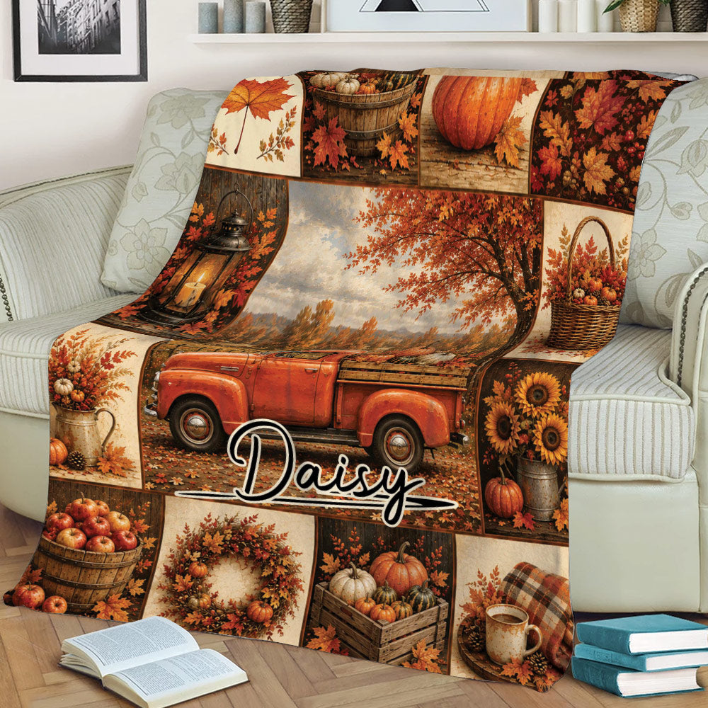Fall-themed throw blanket displayed on a sofa with pumpkins, autumn foliage, a red pickup, and coffee