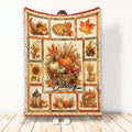 Thanksgiving throw blanket with pumpkins, pie, autumn leaves, corn, sunflowers, and harvest basket artwork