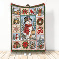 Christmas blanket featuring a cheerful snowman, snowy cabin scenes, wreaths, poinsettias, gifts, and holiday accents