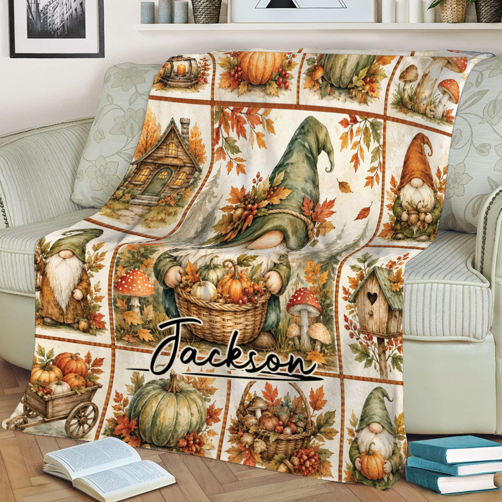 Cozy autumn gnome blanket draped over a couch with pumpkin, mushroom, cottage, and woodland harvest scenes