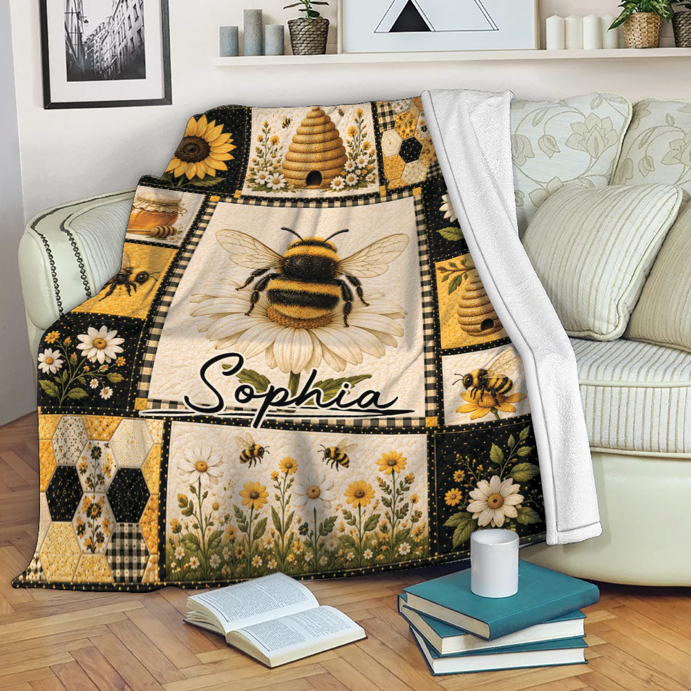 Bee blanket draped over a sofa with honey bee, sunflower, beehive and honeycomb artwork