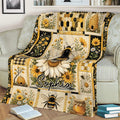 Bee throw blanket displayed on a couch with large bees, wildflowers, honeycomb patterns, and beehive scenes