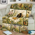 Bee blanket displayed on a sofa with a large bumblebee, daisies, lavender, flower baskets, and garden artwork