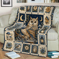 Decorative owl throw blanket draped over a sofa with vintage botanical artwork and deep blue accents