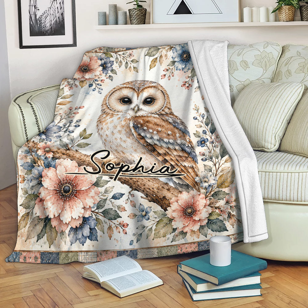 Floral owl blanket draped over a sofa with an illustrated woodland design