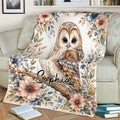 Close view of an owl throw blanket with watercolor flowers, leaves, and branch artwork