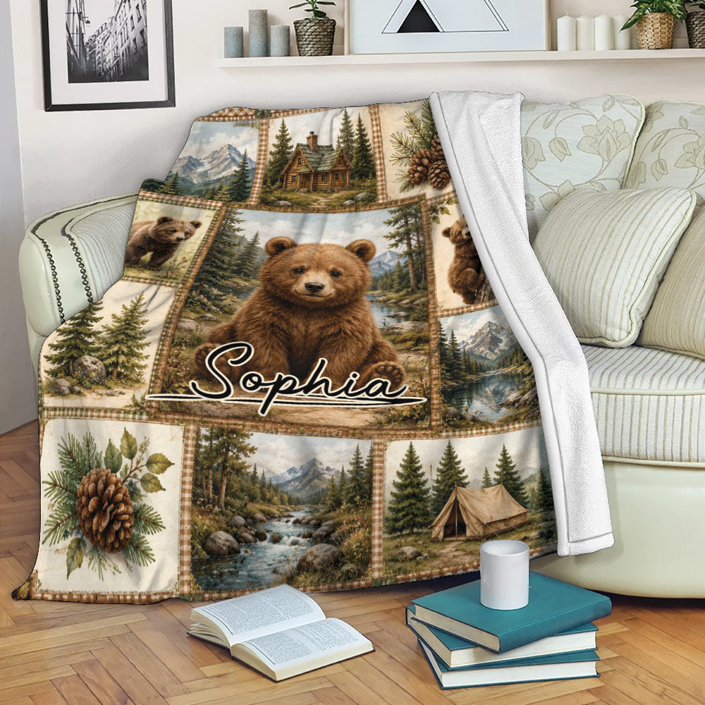 Bear throw blanket draped over a sofa with mountain, cabin, pine forest and woodland artwork