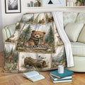 Bear woodland throw blanket displayed on a sofa with forest scenery, wildlife, and rustic cabin artwork