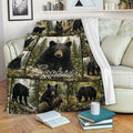 Bear blanket draped over a sofa, showing black bears in a detailed evergreen forest scene
