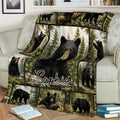 Cozy couch display of a bear throw blanket with woodland wildlife artwork