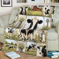 Rustic cow throw blanket draped over a sofa with dairy cows, wildflowers, a barn, and windmill artwork