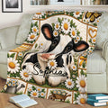 Floral cow calf blanket displayed on a sofa with daisies, a butterfly, watering can, and garden cart