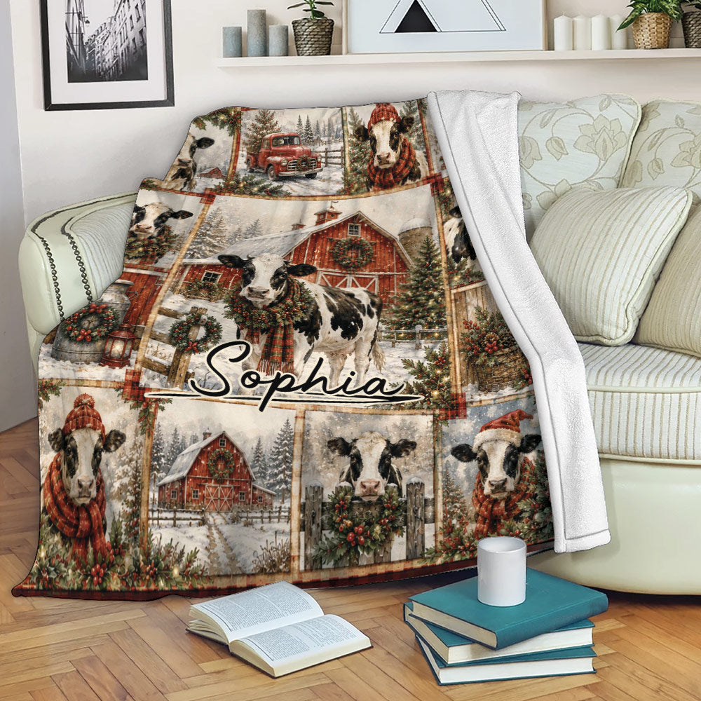 Christmas cow throw blanket displayed on a sofa with snowy farm artwork, festive wreaths, and barn scenes