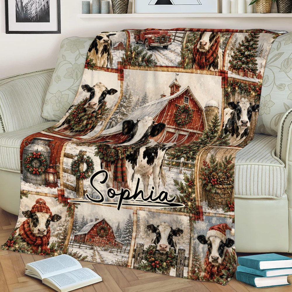 Rustic Christmas cow blanket draped over a sofa with snowy barn, wreath, and festive farm artwork