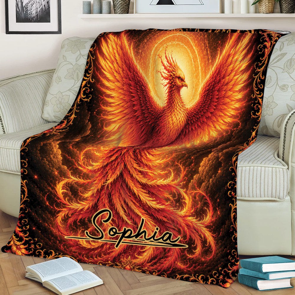Phoenix throw blanket displayed on a couch with dramatic flames, glowing wings, and rich red and gold tones