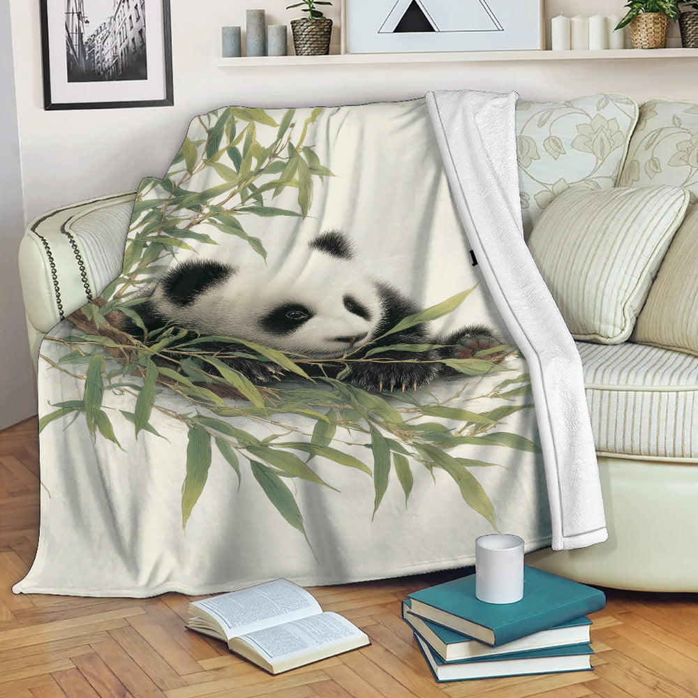 Panda blanket draped over a sofa with bamboo artwork, books, and a cozy reading space