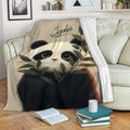 Panda blanket draped over a sofa with bamboo artwork in a cozy living room setting