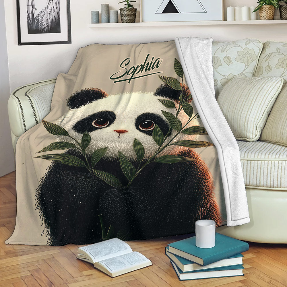 Panda blanket draped over a sofa with bamboo artwork in a cozy living room setting